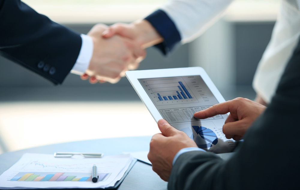 Business associates shaking hands in office